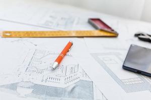 Interior designer's working table, an architectural plan of the house, a color palette, furniture and fabric samples in yellow and grey color. Drawings and plans for house decoration photo