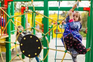 Active little girl playing on a playground photo