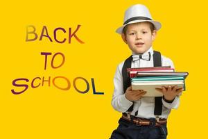 Back to school. Child from elementary school with book and bag. Education. Kid with a book photo