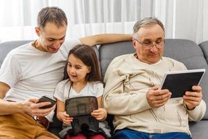 grandfather and granddaughter, father with smartphone at home photo