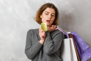 beautiful woman with many shopping bags on gray background photo