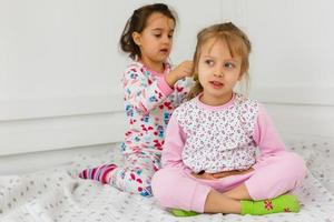 fiesta de pijamas y amistad. fiesta de pijamas de dos niños pequeños felices en el dormitorio. amistad de niñas pequeñas con caras felices. sí. foto