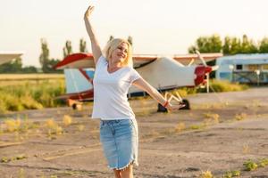 Lonely girl at near airplane. Photo in old image style.