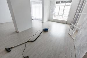 Cleaning of the apartment. Vacuum cleaner on the floor photo