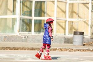 Little pretty girl on roller skates in helmet photo