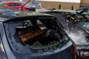 Two cars after the fire. Two burned out cars with an open hood. Arson, burnt car photo