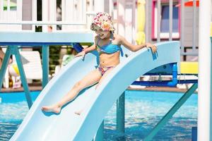 Chica deslizándose en la piscina durante las vacaciones de verano en Turquía foto
