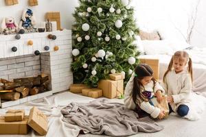 two little girls Sharing a Surprise on Christmas Morning photo