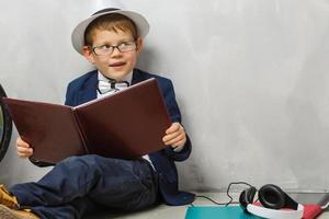 feliz niño curioso niño pequeño genio sobre fondo gris foto