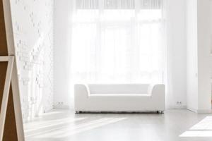 interior luminoso y minimalista de la sala de estar con sofás blancos cerca de la ventana foto