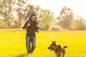 Father and toddler walking with dog photo