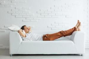 hombre de negocios tranquilo y apuesto durmiendo en el sofá después del trabajo en casa foto