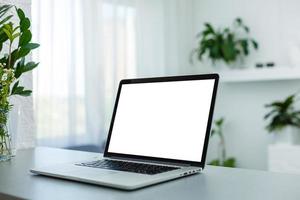 Close up Laptop Computer on Top of Office Table of a Businessman with Empty White Screen, Emphasizing Copy Space photo