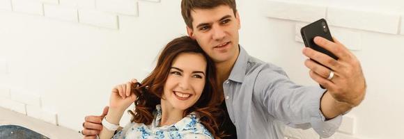 Handsome man making selfie with his pretty woman photo