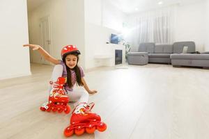 Little girl preschool sitting wearing her roller skates and crossing her legs photo