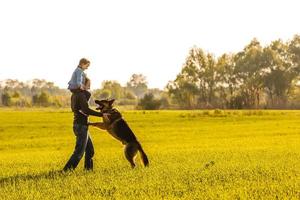 Father and toddler walking with dog photo