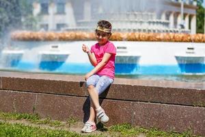 vida amorosa. niña alegre divirtiéndose y posando cerca del agua azul de la fuente. vacaciones de verano. niño feliz en un día caluroso de verano. foto