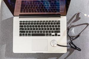 Computer or data analysis - Stethoscope over a laptop computer keyboard toned in blue photo