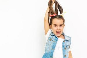 Hair care concept with portrait of little girl holds hair isolated on white photo