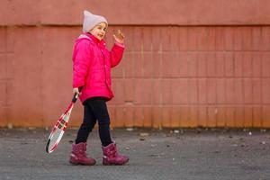 Little cute girl playing tennis outdoors photo