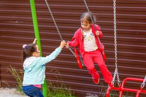 Young child on swing in playground outdoors photo