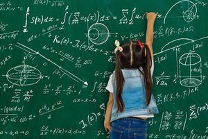 Girl against big board with formulas, back view photo