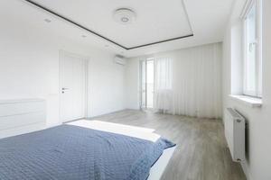 Simple exclusive white bedroom with wooden parquet photo