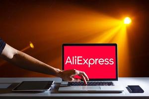 Kyiv, Ukraine  November 10, 2019 man holding macbook pro with Internet shopping service Aliexpress on the screen. photo