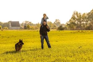 Father and toddler walking with dog photo