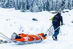 esquiador de rescate del equipo de patrulla de esquí con la pierna rota foto