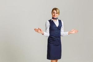 retrato de una encantadora azafata vestida con uniforme azul. aislado sobre fondo blanco foto