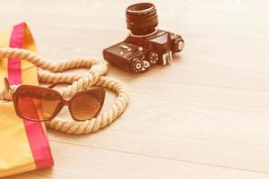 Packed suitcase of vacation items on wooden table, top view. photo