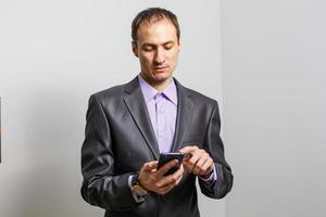 Smiling Young Middle Eastern Man With smartphone photo