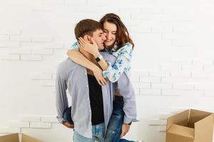 pareja sonriente apoyándose en cajas en un nuevo hogar foto