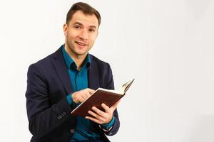 Portrait with copy space, empty place of stylish trendy teacher in shirt, jacket with stubble having three books in hands, looking at camera isolated on  background photo