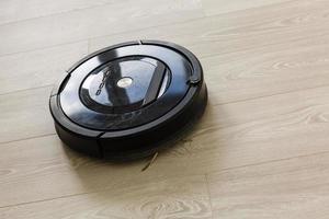 Robotic vacuum cleaner on laminate wood floor smart cleaning technology photo