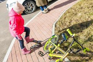 una niña infla un neumático de bicicleta foto