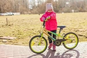 little girl riding bicycle in city park. photo