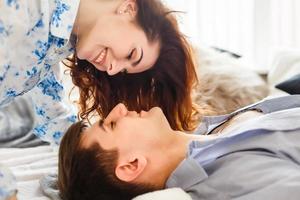 Real love. Beautiful young couple bonding and smiling while sitting in the bedroom photo