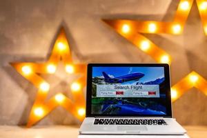 lights online booking and reservation. Search flights on a computer laptop screen, office desk background photo