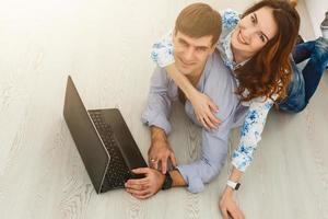 pareja comprando en línea junto con una computadora portátil en una computadora de escritorio en casa foto