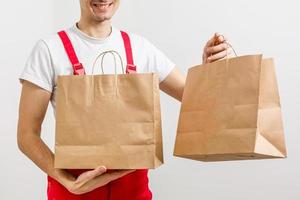 Diverse of paper containers for takeaway food. Delivery man is carrying photo