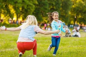 beautiful young mother and her daughter having fun at the field photo