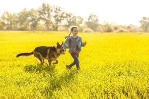 Little girl with dog running on the road photo