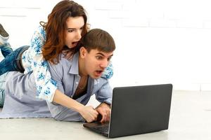 Couple buying online together with a laptop on a desktop at home photo