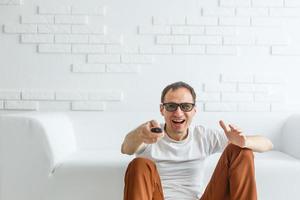 Mature Man Sitting On Couch Watching Television photo