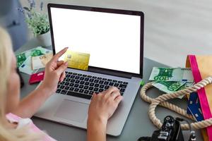 Close up of asian woman hands holding credit card and using laptop computer at coffee shop to perform shopping online by inputting card information for payment method. Ecommerce business concept. photo