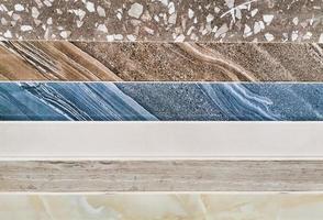 A stack of multi-colored marble slabs. Samples of decorative facing stone close-up. Beautiful colorful stone wall background. Selective focus photo