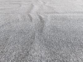 Seamless close up of monochrome grey carpet texture background from above photo