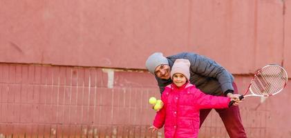 Active family playing tennis on court photo